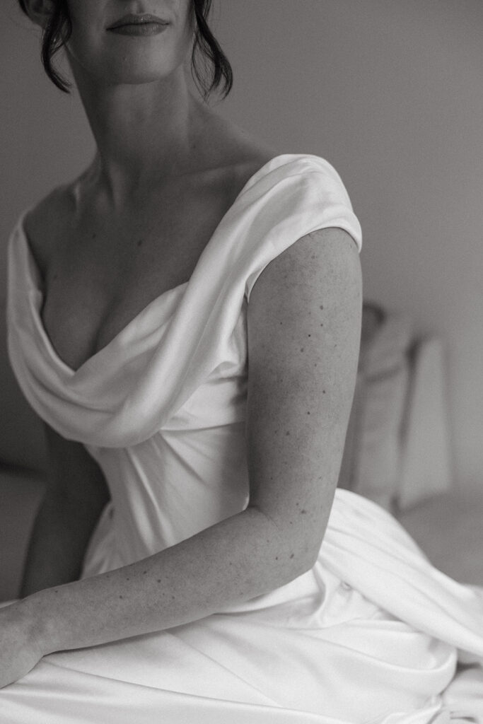 Bride sitting in stillness, wrapped in light and anticipation.