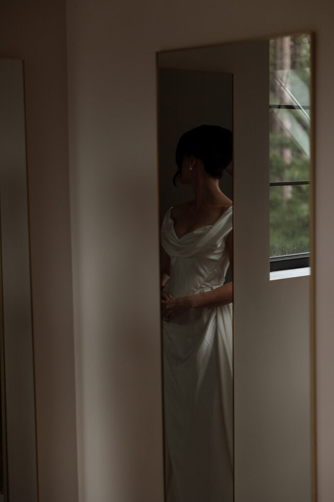Bride catching her reflection, one last glance before walking out.