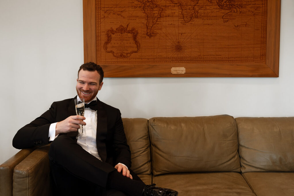 Sitting beneath the carved world map in the suite, calm before the vows.