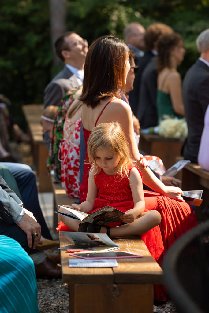 A guest reads to her daughter before the ceremony starts, calm in the midst of the buzz.