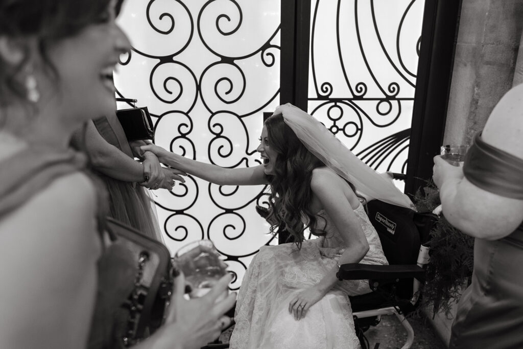 Comedian Fiona Cauley doubles over in laughter while chatting with her bridesmaids before the wedding ceremony began