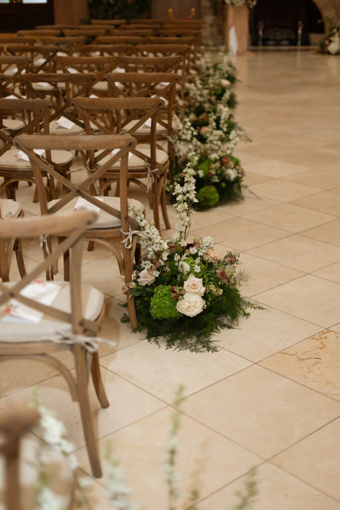 Floral meadows line the aisle of Union Station in Nashville as natural wood bistro chairs wait for guests to arrive. 