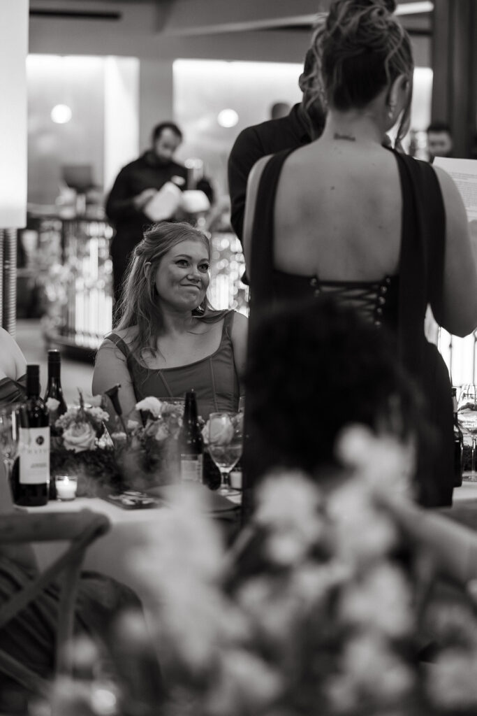 Guest listens aptly to speeches in emotional black and white moment captured by documentary wedding photographer