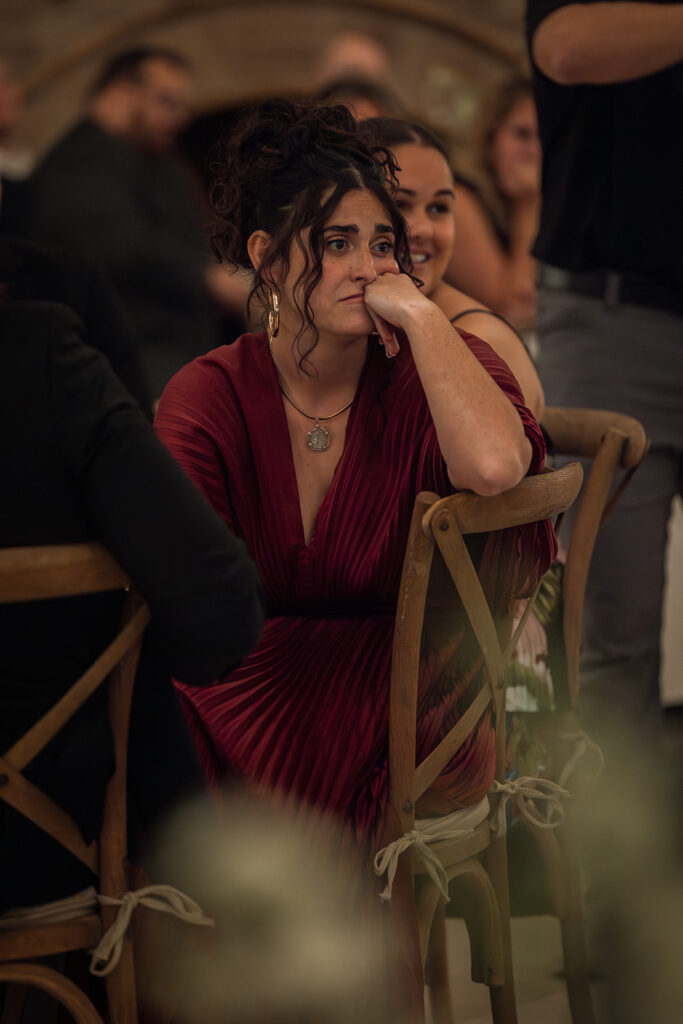 Wedding guest in red dress can't fight back the tears during emotional speech