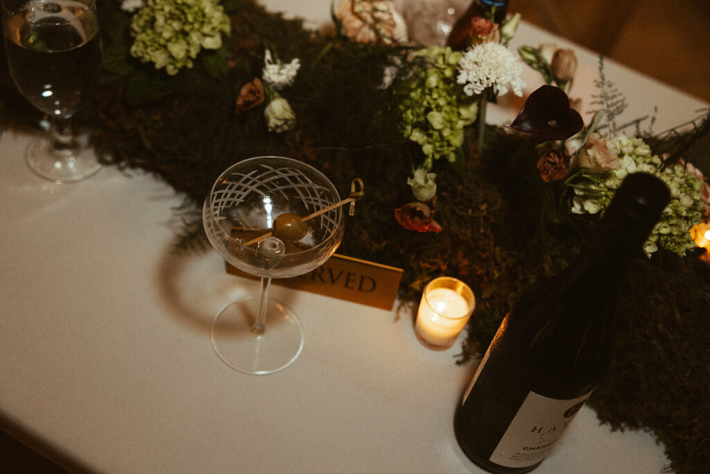 Olives in coup glass surrounded by rich florals on a table at Union Station in Nashville. 