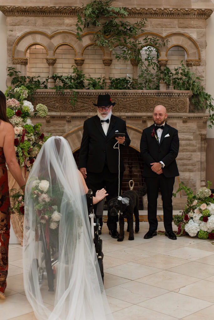 Bride wheels her chair towards her groom while her veil trails gently behind her