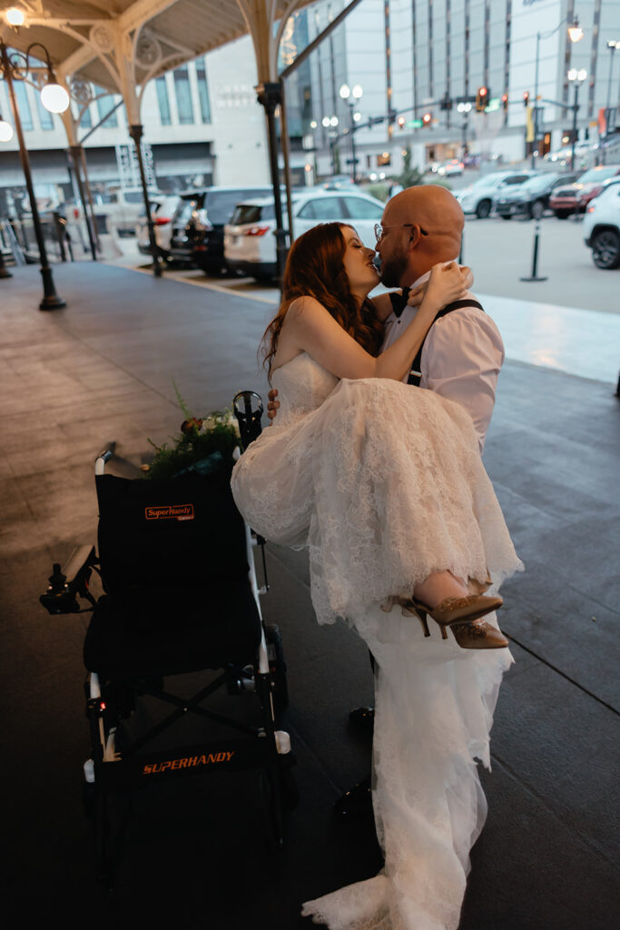 Groom carries his bride to her wheelchair in highly emotive shot by documentary wedding photographer in Nashville