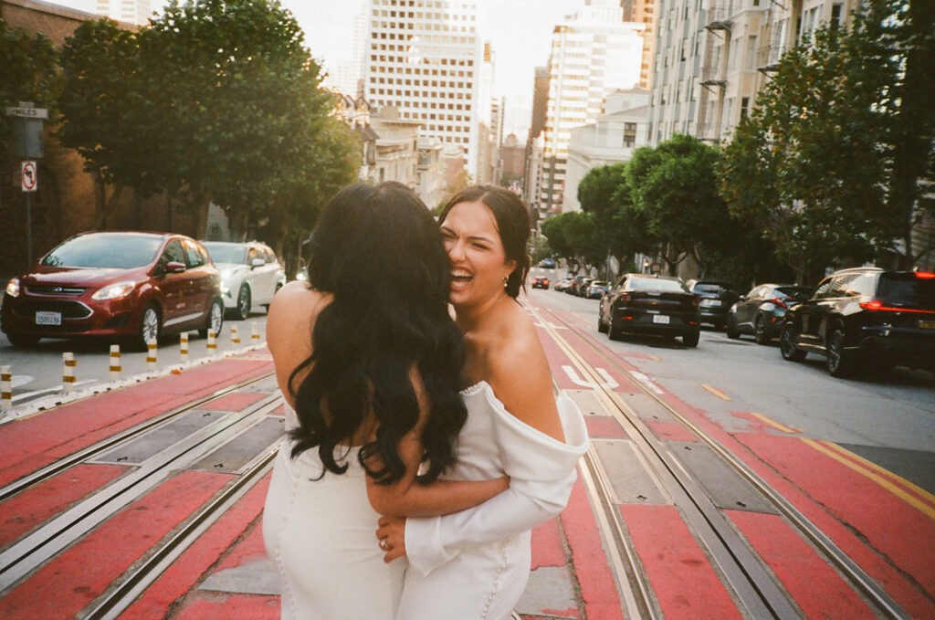 Brides stand in the middle of San Francisco traffic in candid moment showcasing Nashville wedding photographer's philosophy