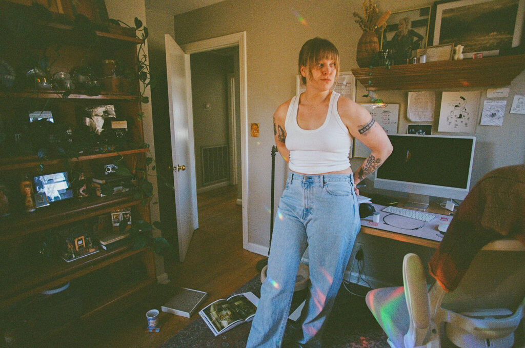 Nashville photographer Ali Miller standing inside her home office surrounded by books, cameras, and creative inspiration during an in-home branding session.