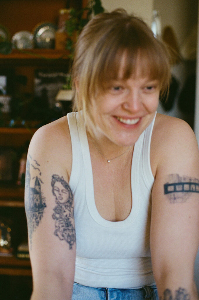 Candid portrait of documentary photographer Ali Miller laughing naturally while working inside her Nashville home.