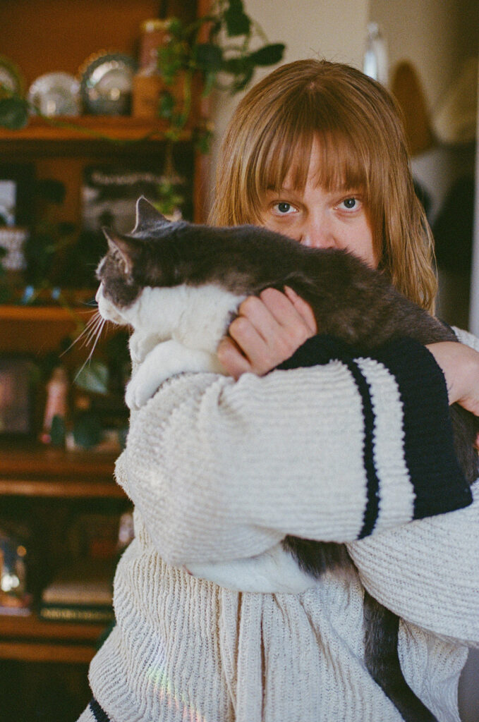 Nashville photographer Ali Miller holding her cat, Minerva, during relaxed in-home branding photos celebrating everyday life.