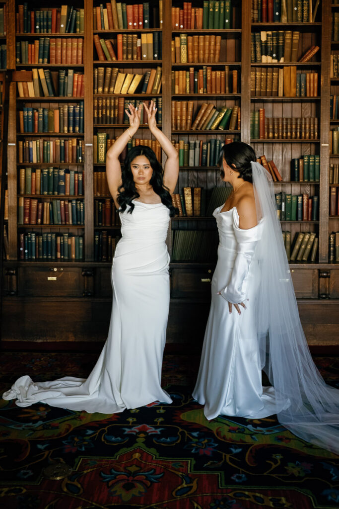 Two brides share a goofy emotional moment after their first look at University Club of San Francisco
