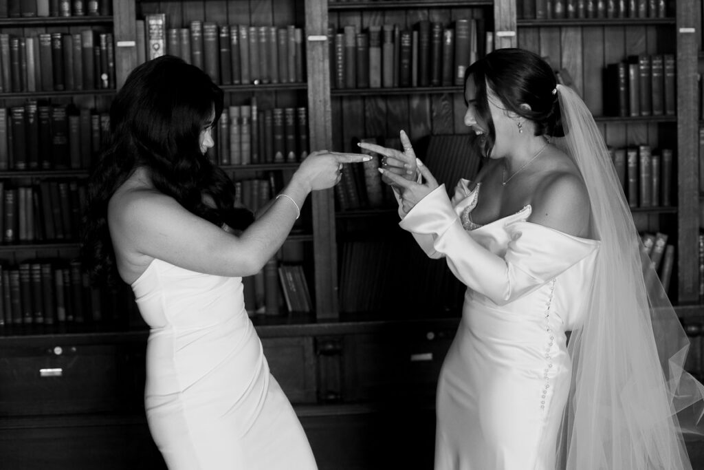 Lesbian bridges give each other finger guns, showing what candid wedding photography really means