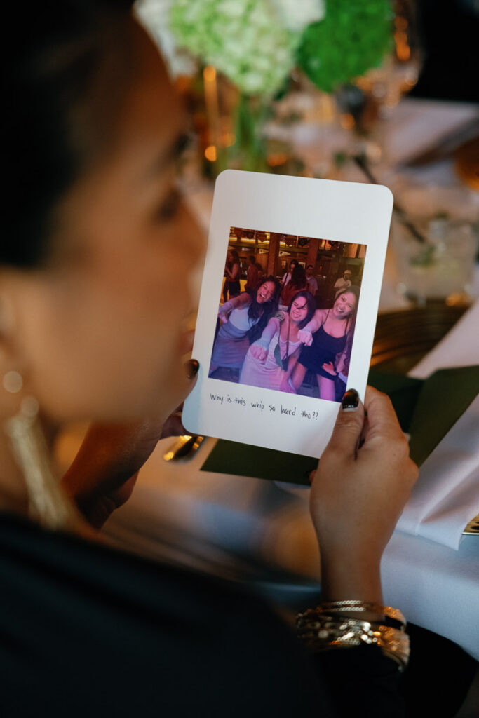 Wedding guest looks at her personal letter and photograph from the bride, showing how to shape a meaningful guest experience at your wedding
