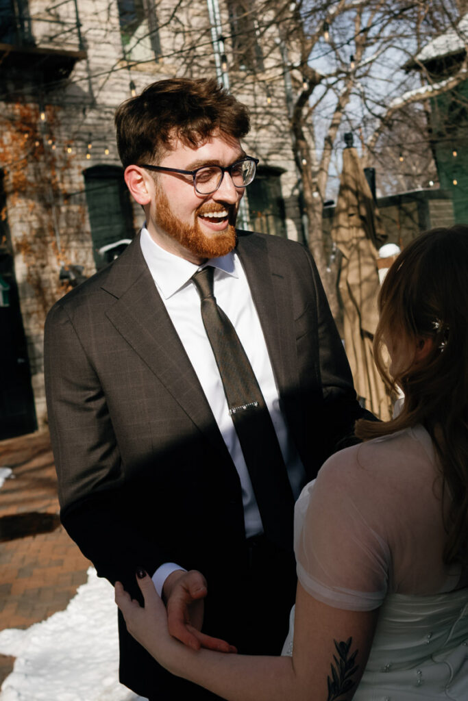 Groom grins down at his bride during candid moment after disrupting the planned first look