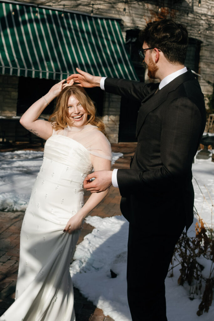 Groom twirls bride in the sunshine during winter wedding in Saint Paul, Minnesota